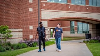 Two students walk outside of TCC's West Campus