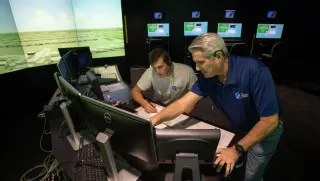 A professor and student look at a computer within TCC's air traffic control simulator.