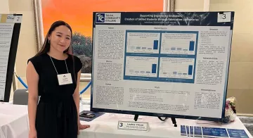 Leahla Chism stands next to her research presentation