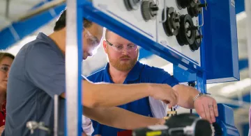 A student tinkers with a mechanical part.