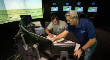 A professor and student look at a computer within TCC's air traffic control simulator.