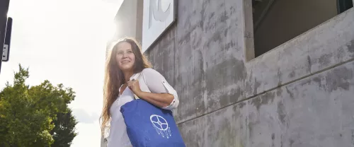 woman holding blue tote bag