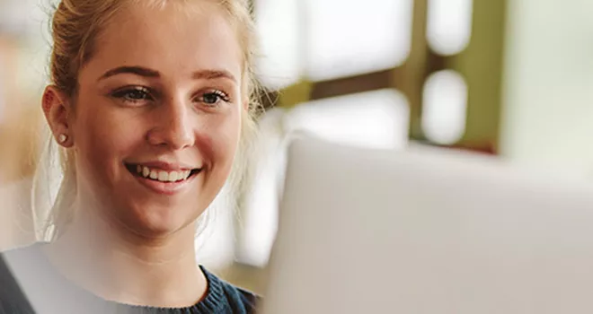 Young female student works at a laptop.