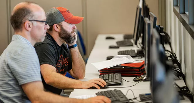 two men looking at computers