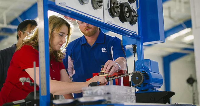 woman and man working on a machine