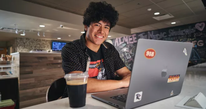 TCC student self-enrolls in classes on his lap top while sitting in the on-campus coffee shop.