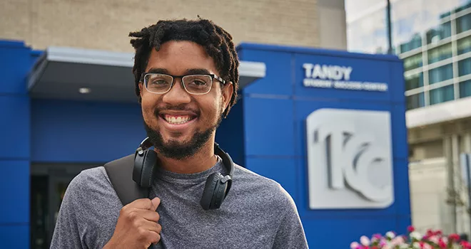 TCC student stands outside the entrance to metro campus Tandy student success center