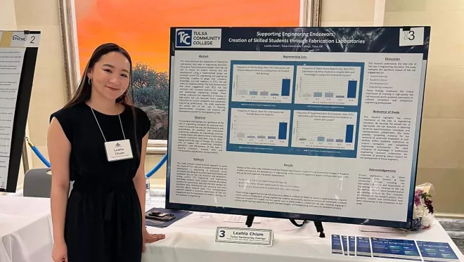 Leahla Chism stands next to her research presentation