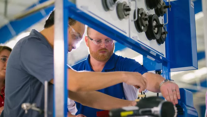 A student tinkers with a mechanical part.