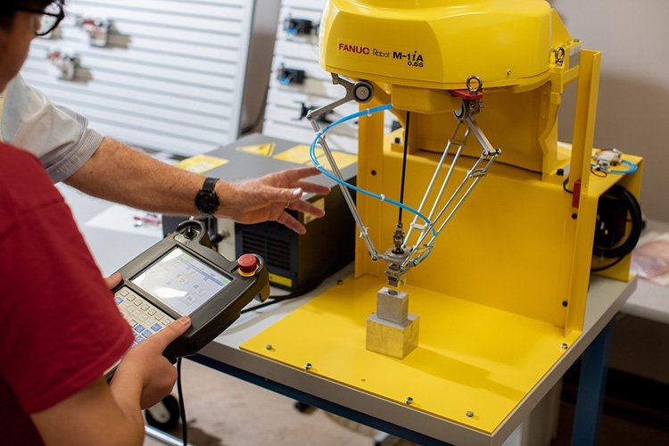 TCC student operates manufacturing robot.