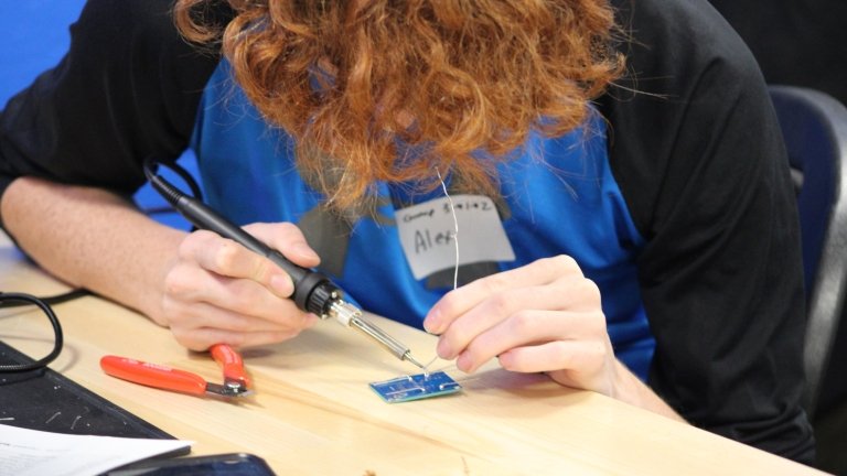 A student solders a circuit board