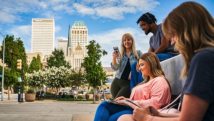 TCC Students sit on a bench outside the Metro Campus.